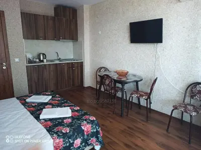 a room with a bed and a table and chairs at Студио под наем Елина 31 in Shkorpilovtsi