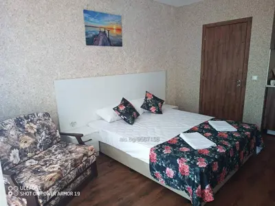 a hotel room with a bed and a chair at Студио под наем Елина 31 in Shkorpilovtsi
