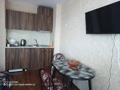 a living room with a table and chairs and a television at Студио под наем Елина 31 in Shkorpilovtsi