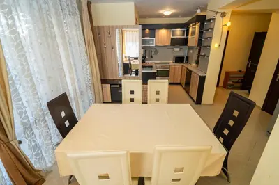 a dining room table and chairs in a kitchen at The Family Courtyard - Very LARGE 2BD Apartment by Flat Manаger in Ravda