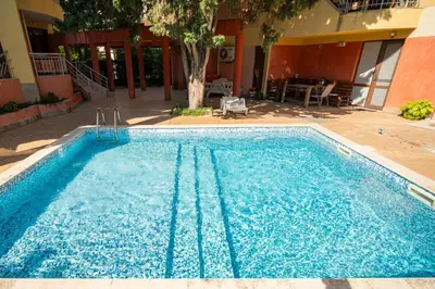 a large blue swimming pool next to a building at The Family Courtyard - Very LARGE 2BD Apartment by Flat Manаger in Ravda