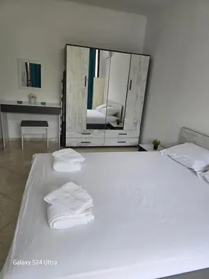 a white bed with two towels on it with a mirror at Elia Relax & Lux in Aheloy
