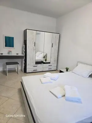 a bedroom with a large white bed with a mirror at Elia Relax & Lux in Aheloy