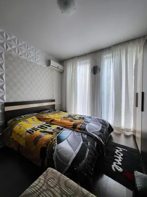 a bedroom with a bed with a colorful comforter at Sunny View SP apartments in Bŭnzareto