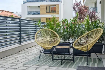 two chairs and a table on a balcony at BellaViaStay, Flat Apolonia 1BD in Burgas City