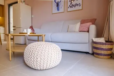 a living room with a couch and a ottoman at BellaViaStay, Flat Apolonia 1BD in Burgas City