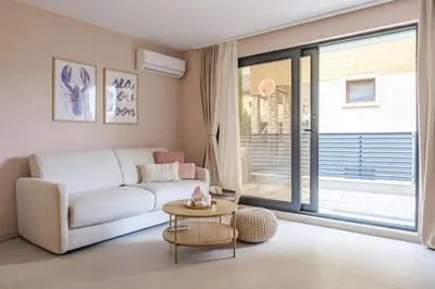 a living room with a white couch and a table at BellaViaStay, Flat Apolonia 1BD in Burgas City