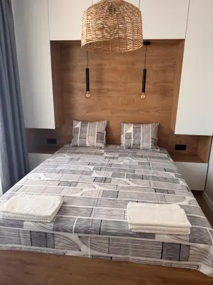 a bedroom with a large bed with a wooden headboard at South Beach Apartment Primorsko 2 in Primorsko