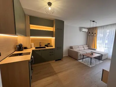 a kitchen and a living room with a couch at South Beach Apartment Primorsko 2 in Primorsko