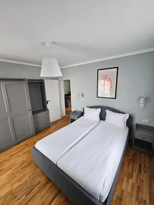a bedroom with a large white bed and a television at Flowers Apartments in Nesebar
