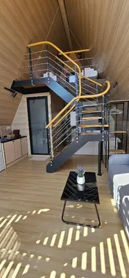 a living room with a spiral staircase and a table at Elysium Lozenets in Lozenets