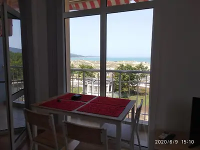 a table and chairs with a view of a balcony at Apartment Stoyanovi in Primorsko