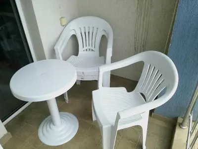two white chairs and a white table and chair at Apartment Stoyanovi in Primorsko