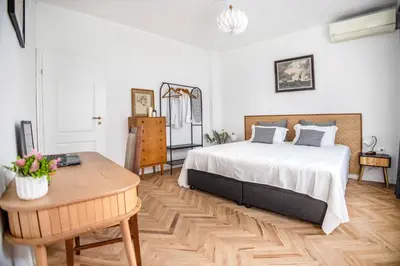 a bedroom with a large bed and a table at Downtown Central point Varna Apartment in Varna City