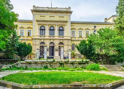 a large building with a garden in front of it at Downtown Central point Varna Apartment in Varna City