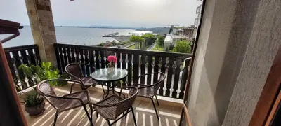 a table and chairs on a balcony with a view of the water at Tryavna Beach Violet 42 in Sveti Vlas