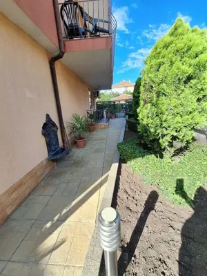 a walkway leading to a building with a balcony at Къща за гости Авеню in Ravda