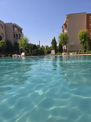a large pool of blue water in front of a building at Orchid Fort Garden in Sunny Beach