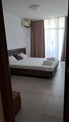 a bedroom with a bed and a window at Grand Кameliq - MORSKI BRIZ apartment in Sunny Beach
