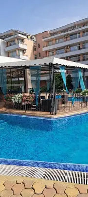 a large swimming pool with a canopy over a building at Grand Кameliq - MORSKI BRIZ apartment in Sunny Beach