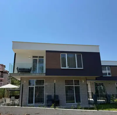 a large house with chairs in front of it at Aurum Villas Smokinya Beach 2 in Sozopol