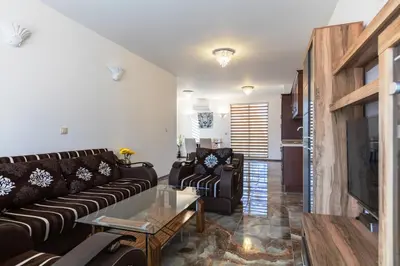 a living room with a couch and a tv at Boutique Apart Hotel Versis in Sunny Beach