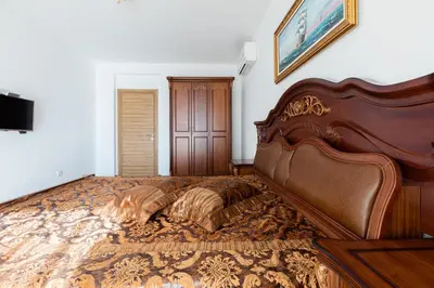 a bedroom with a large bed with a wooden headboard at Boutique Apart Hotel Versis in Sunny Beach