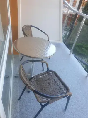 a table and a chair on a balcony at Hotel Maria in Kiten