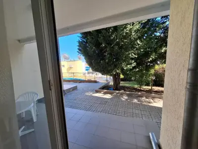 an open door to a patio with a tree at Sunset Complex Кошарица Апартамент 15 in Kosharitsa