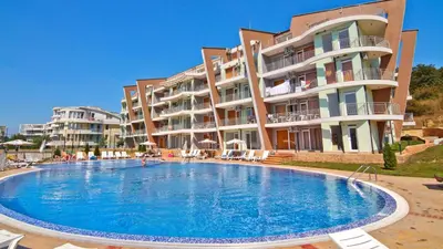 a large swimming pool in front of a building at Sunset Complex Кошарица Апартамент 15 in Kosharitsa