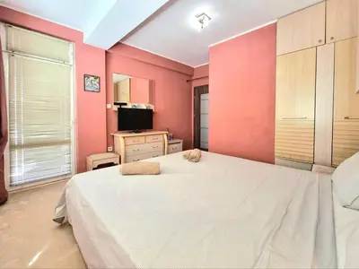 a bedroom with a white bed and pink walls at Aquapark 2BD Apartment for Family in Sunny Beach
