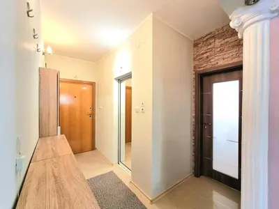 a hallway with a door and a brick wall at Aquapark 2BD Apartment for Family in Sunny Beach