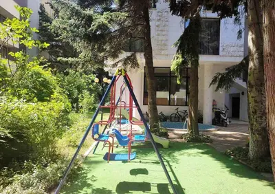 a playground in a yard with a swing at Blue Beach Apartments - Amara in Ravda