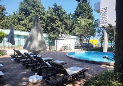 a group of chairs and umbrellas next to a pool at Blue Beach Apartments - Amara in Ravda