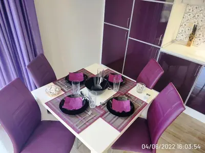 a table with purple chairs and a white table with a tableablish at Blue Beach Apartments - Amara in Ravda