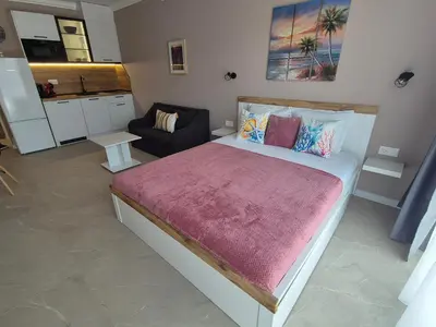 a bedroom with a large bed and a couch at Verano Deluxe Studios in Burgas City