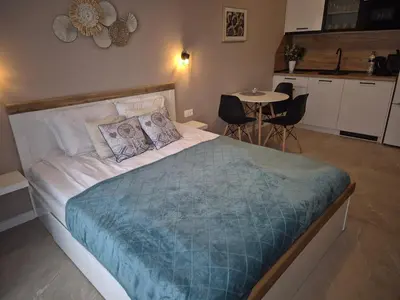a bedroom with a bed and a table with chairs at Verano Deluxe Studios in Burgas City