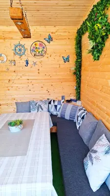 a room with two beds and a wooden wall at Еко Къщи Градина in Sozopol