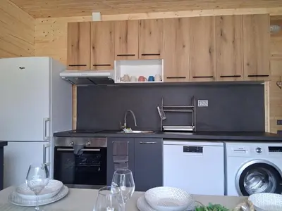 a kitchen with a washing machine and a refrigerator at Еко Къщи Градина in Sozopol