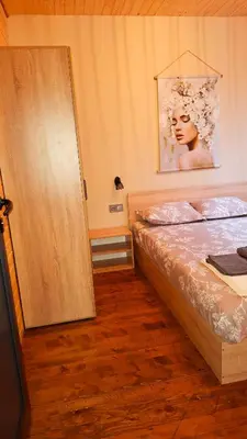 a bedroom with a bed and a wooden door at Еко Къщи Градина in Sozopol