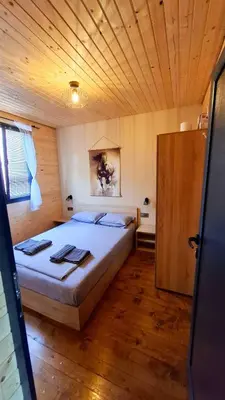 a bedroom with a bed and a wooden ceiling at Еко Къщи Градина in Sozopol