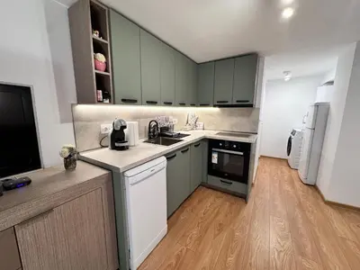 a kitchen with green cabinets and a white refrigerator at Studio Briz in Burgas City