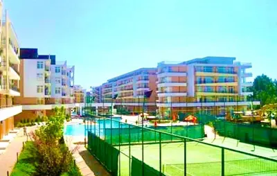 a tennis court in front of some buildings at Apartcomplex Grand Kamelia Sunny Beach in Sunny Beach