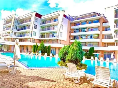 a swimming pool in front of a large building at Apartcomplex Grand Kamelia Sunny Beach in Sunny Beach