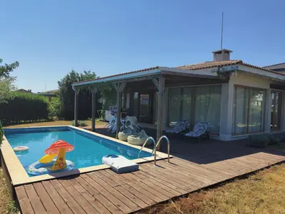 a swimming pool on a wooden deck next to a house at Villa Casablanca with private pool in Lozenets