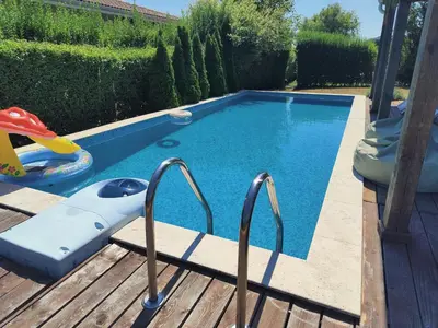 a small swimming pool with two metal rails next to a wooden deck at Villa Casablanca with private pool in Lozenets