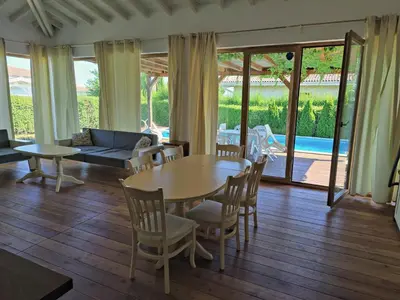 a living room with a table and chairs and a couch at Villa Casablanca with private pool in Lozenets