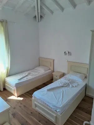 two beds in a room with wooden floors at Villa Casablanca with private pool in Lozenets