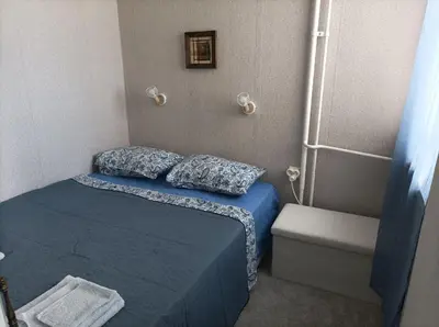 a small bedroom with a blue bed and a shower at Sunrise home in Burgas City