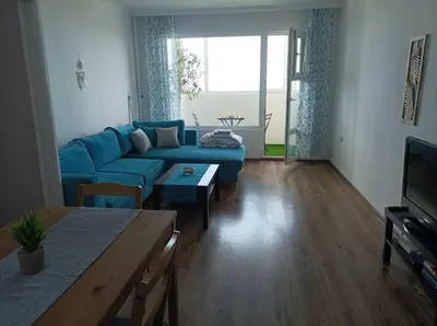 a living room with a blue couch and a table at Sunrise home in Burgas City